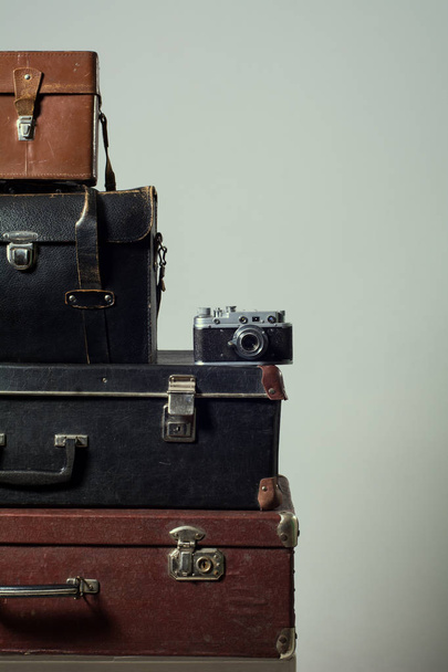Stack of vintage shabby suitcases and camera - Fotografie, Obrázek