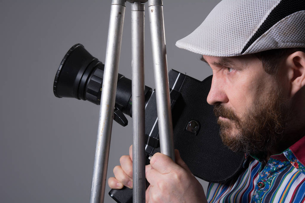 Γενειοφόρος άνδρας φωτογραφική μηχανή κινηματογράφων τρίποδο - Φωτογραφία, εικόνα