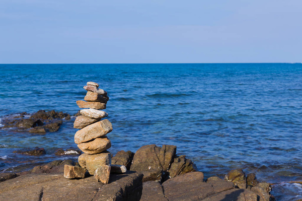 Pedra de pilha sobre o horizonte do litoral
 - Foto, Imagem