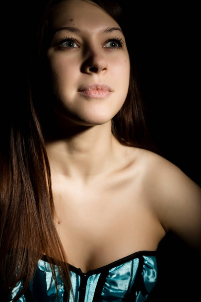portrait of sexy young woman in corset with lacing posing on a dark background - Valokuva, kuva