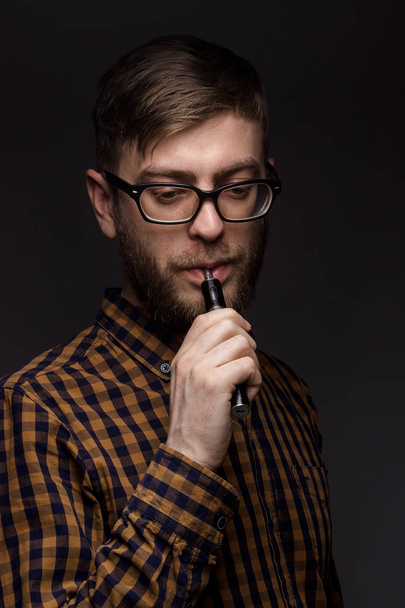 man with a beard smoking Vape - Fotoğraf, Görsel