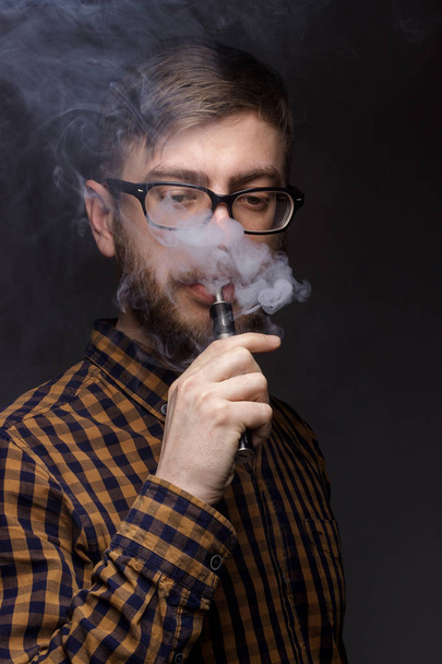 man with a beard smoking Vape - Фото, изображение