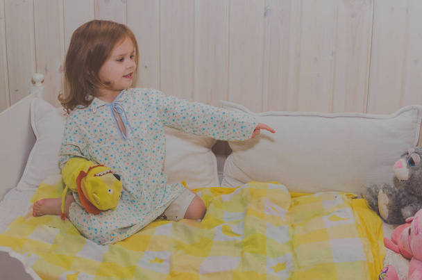 baby girl in bed plays with soft toys - Zdjęcie, obraz