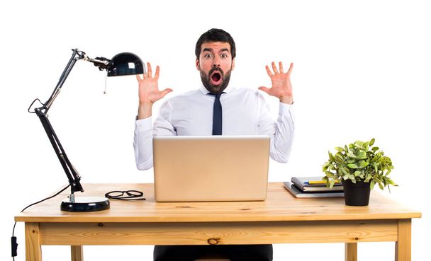 Businessman in his office doing surprise gesture - Photo, Image