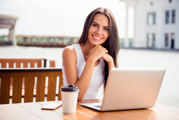 Young smiling woman in outdoor cafe drinking coffee and working  - Φωτογραφία, εικόνα