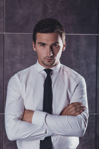 Portrait of successful young businessman with crossed hands  on  - Фото, изображение