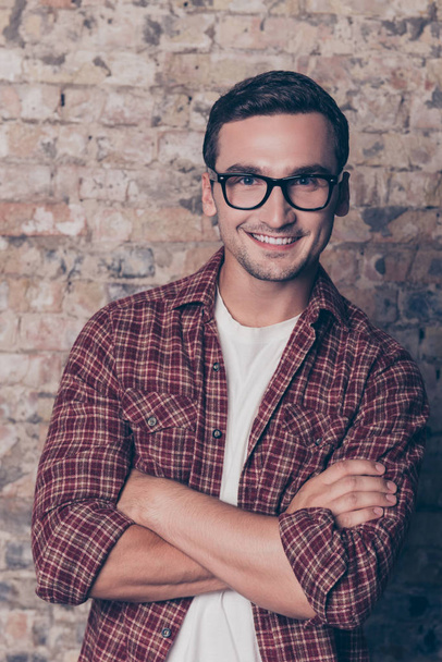 Portrait of handsome smiling man in glasses with crossed hands - Fotó, kép