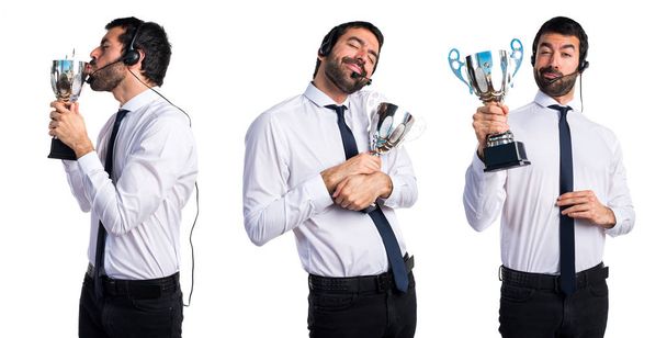 Handsome telemarketer man holding a trophy - Fotoğraf, Görsel