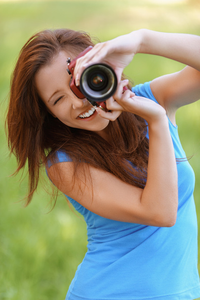 young woman smiles and photographs - Foto, afbeelding