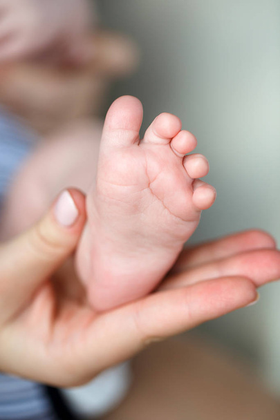 Feet of newborn baby on mother's palm - Valokuva, kuva