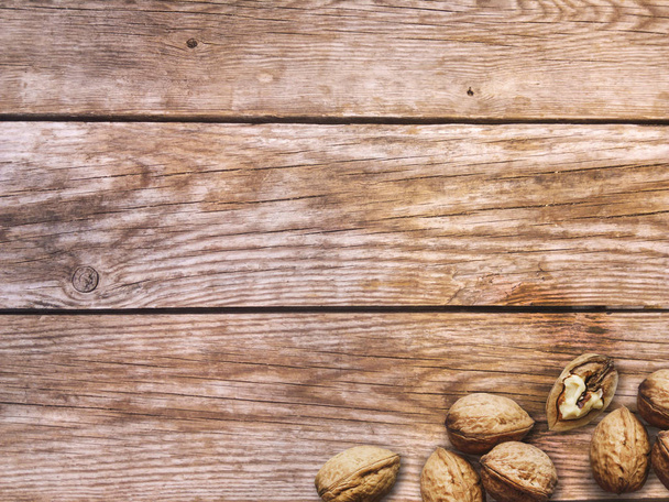 Pähkinöitä. Kokonaiset ja kuoritut saksanpähkinät puupohjalla
 - Valokuva, kuva