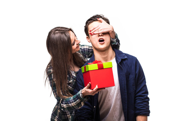 Les jeunes couples partagent un cadeau. Fille fermer les yeux avec les mains et donner un cadeau pour son petit ami
. - Photo, image