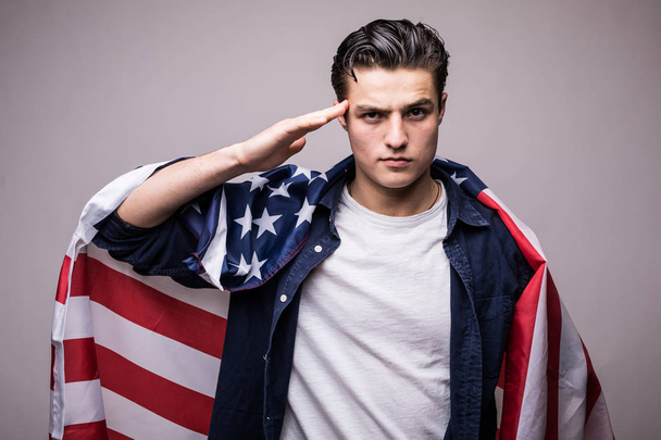 Homem elegante coberto com bandeira americana olhando para a câmera e saudação
 - Foto, Imagem