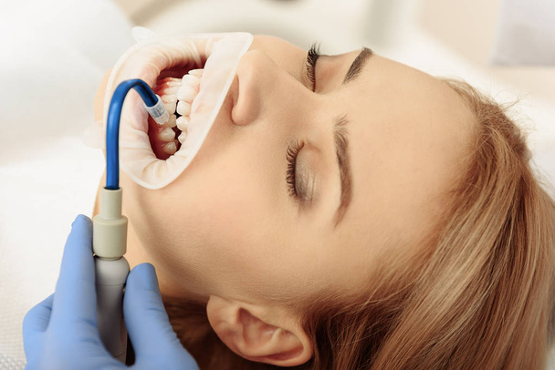 Stomatologist putting saliva aspirator in oral cavity of client - Foto, immagini