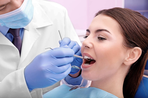 Dentist examining patients teeth - Foto, afbeelding