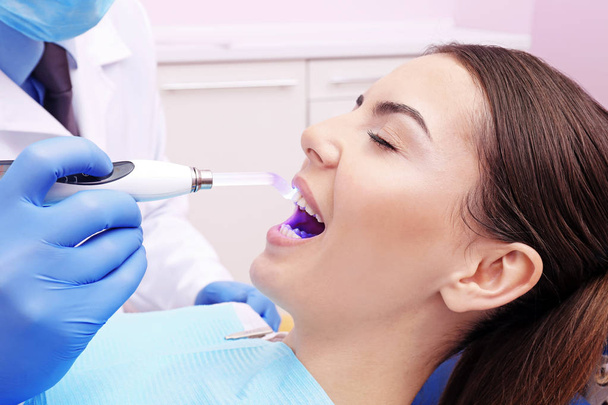 Dentist examining tooth of young woman in clinic - Φωτογραφία, εικόνα