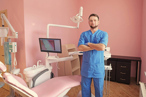 Male dentist at workplace in modern clinic - Foto, afbeelding