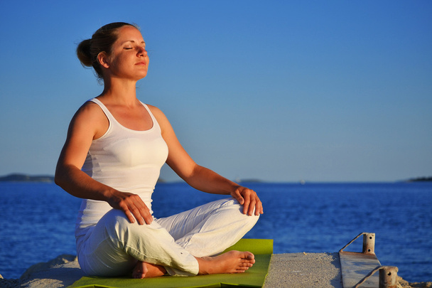 Fiatal nő jóga meditáció közben a strandon - Fotó, kép
