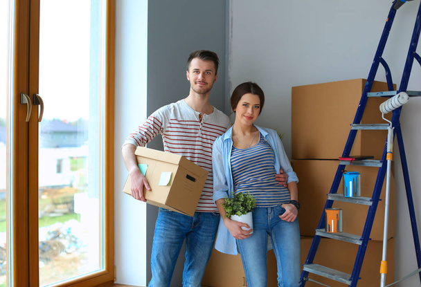 Happy young couple unpacking or packing boxes and moving into a new home - Valokuva, kuva