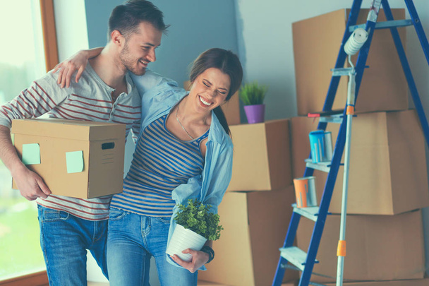Happy young couple unpacking or packing boxes and moving into a new home - 写真・画像