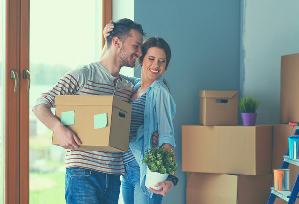 Happy young couple unpacking or packing boxes and moving into a new home - Φωτογραφία, εικόνα