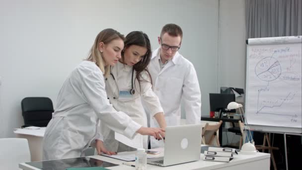 team van artsen die op laptop werkt en analyseren van xray in medische kantoor - Video