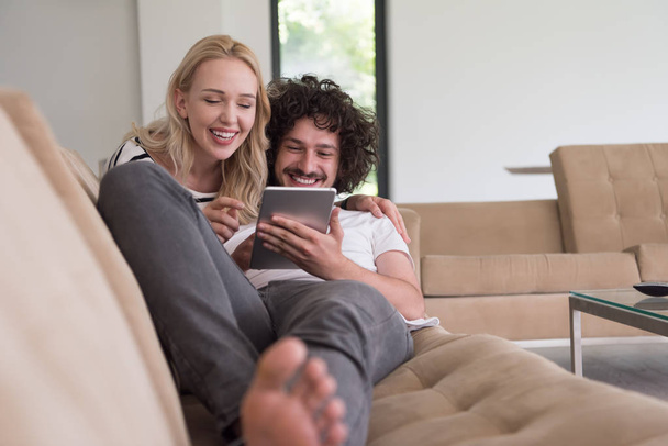 casal relaxante em casa com computadores tablet
 - Foto, Imagem