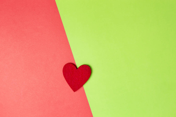 Red heart on colored paper background. Valentine day mockup. Top view. Copy space for text - Foto, Imagem