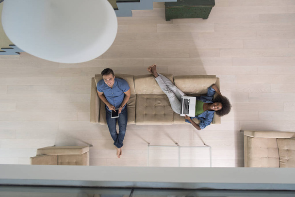 young multiethnic couple relaxes in the living room top view - Fotoğraf, Görsel