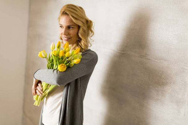 Woman with yellow tulips - Zdjęcie, obraz