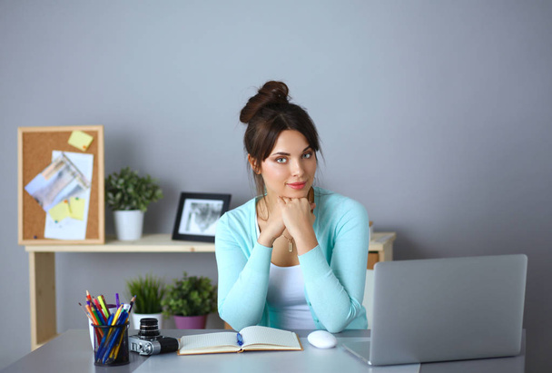 Portrait of businesswoman sitting at desk - Foto, Imagem