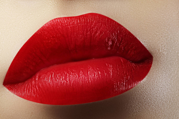Όμορφα Γυναικεία χείλη. Γλυκό φιλί με κόκκινο κραγιόν. Μακιγιάζ χειλιών σε μακροεντολή πυροβολούν. Ζεστό μόδας μακιγιάζ χειλιών - Φωτογραφία, εικόνα