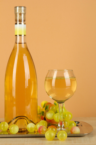 White wine in glass with bottle on salver on beige background - Fotoğraf, Görsel