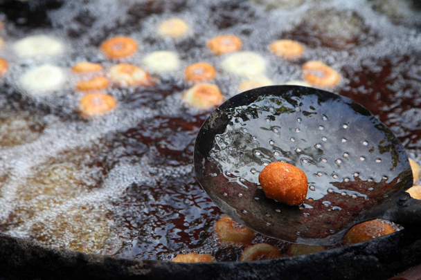 Freír medu vada en la sartén. Medu Vada es un aperitivo salado del sur de la India, comida callejera muy común en la India
. - Foto, imagen