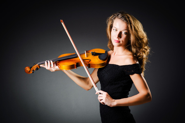 Жінка зі скрипкою в темній кімнаті
 - Фото, зображення