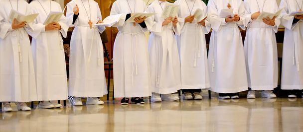 muchos niños con la túnica blanca durante la ceremonia de la fi
 - Foto, imagen