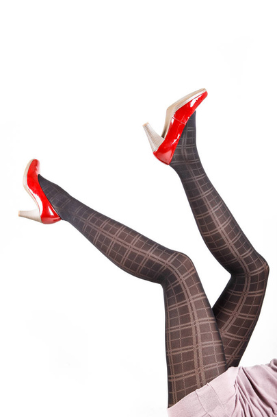 Στα πόδια της γυναίκας, φοράει καλσόν και ψηλά τακούνια - Φωτογραφία, εικόνα