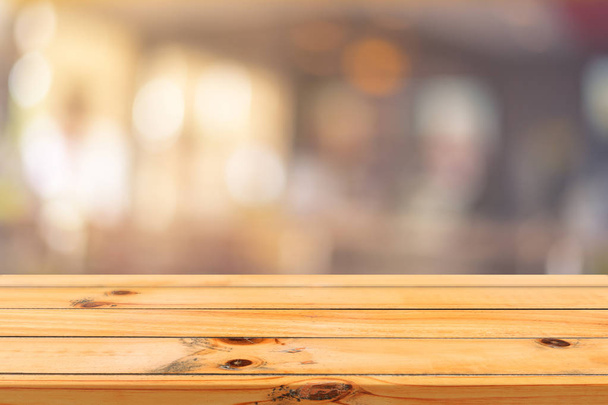 Plateau vide en bois sur fond flou. Perspective table en bois marron sur flou dans le fond du café peut être utilisé modèle pour l'affichage des produits de montage ou la conception mise en page visuelle clé. - Photo, image