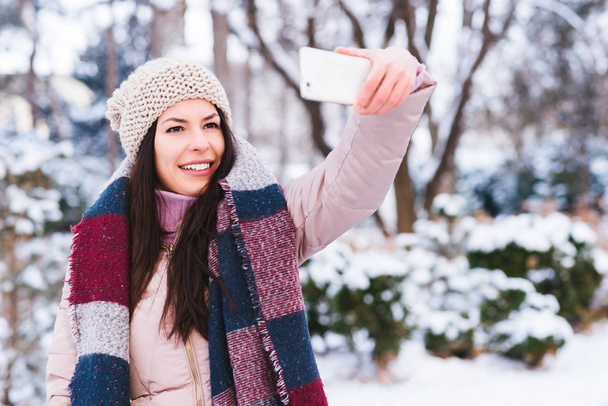 Fiatal nő vesz selfie a smartphone a szabadban - Fotó, kép