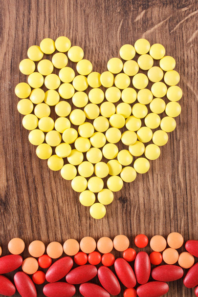 Heart shaped medical pills and capsules, health care concept - 写真・画像