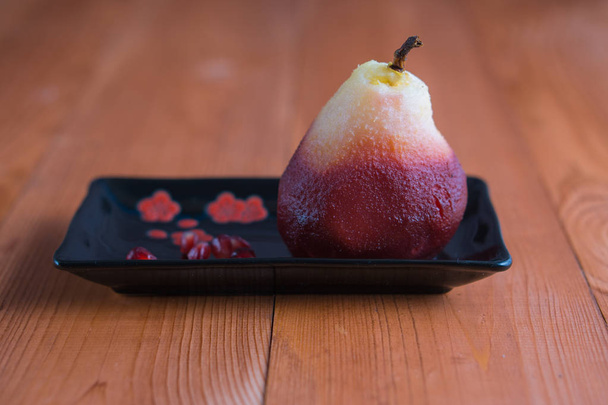 poached pear on black rectangle plate - Фото, зображення