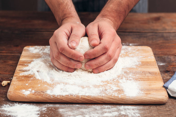 Baker holding raw dough in hands close-up - Fotoğraf, Görsel