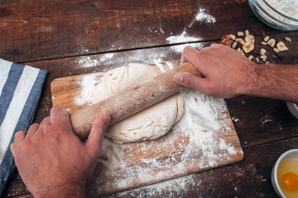 Man rolling dough on cutting board, cook pov - Фото, зображення