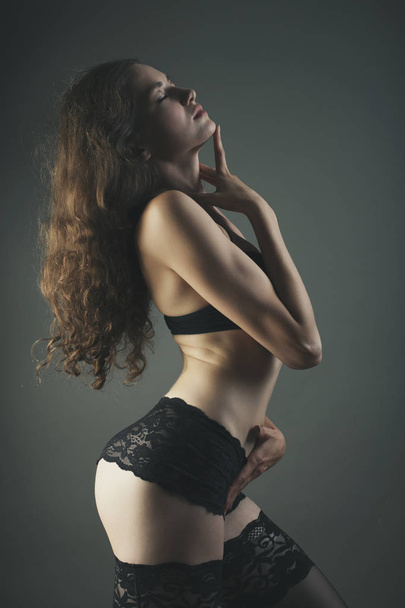 woman in black lingerie on a dark bg studio shot - Photo, image