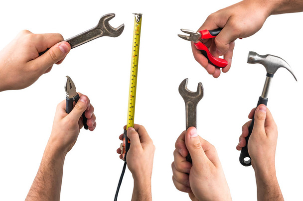 Schraubenschlüssel, Zange, Maßband und Hammer in den Händen der Arbeiter - Foto, Bild