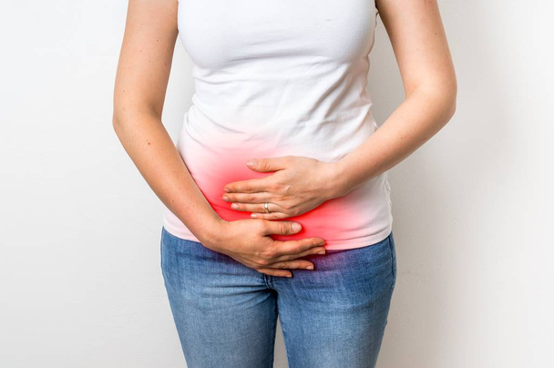 Frau mit Menstruationsschmerzen hält ihren schmerzenden Bauch - Foto, Bild