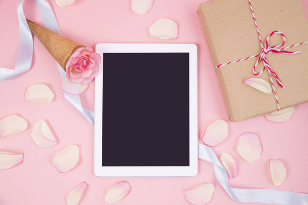 Smartphone with pink petals on pastel background. - Photo, Image