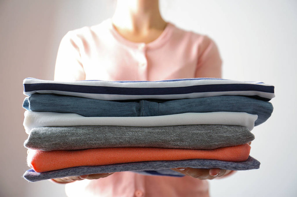 Woman holding folded clothes - Foto, afbeelding