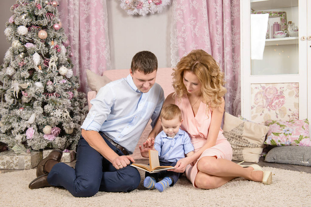 happy parents with toddler boy read the book in Christmas - Φωτογραφία, εικόνα