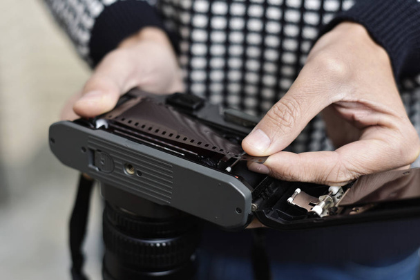 чоловік змінює рулонну плівку своєї камери
 - Фото, зображення